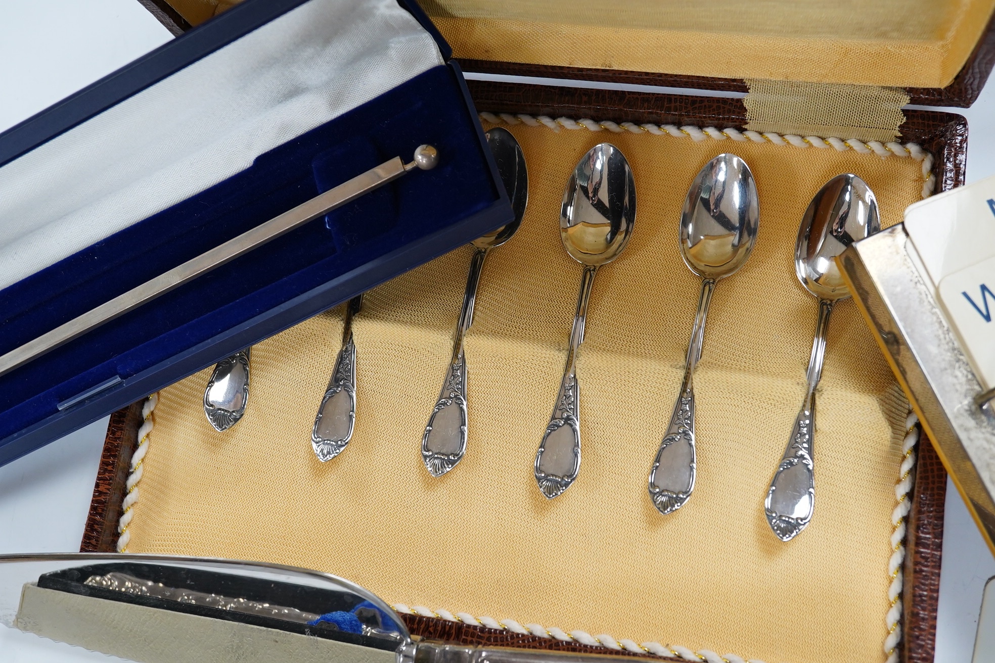 Sundry silver including a silver handled cake slice and similar bread knife, a cased set of six Italian 800 standard coffee spoons, a modern silver mounted desk calendar and an unusual 925 long olive spoon? with removabl